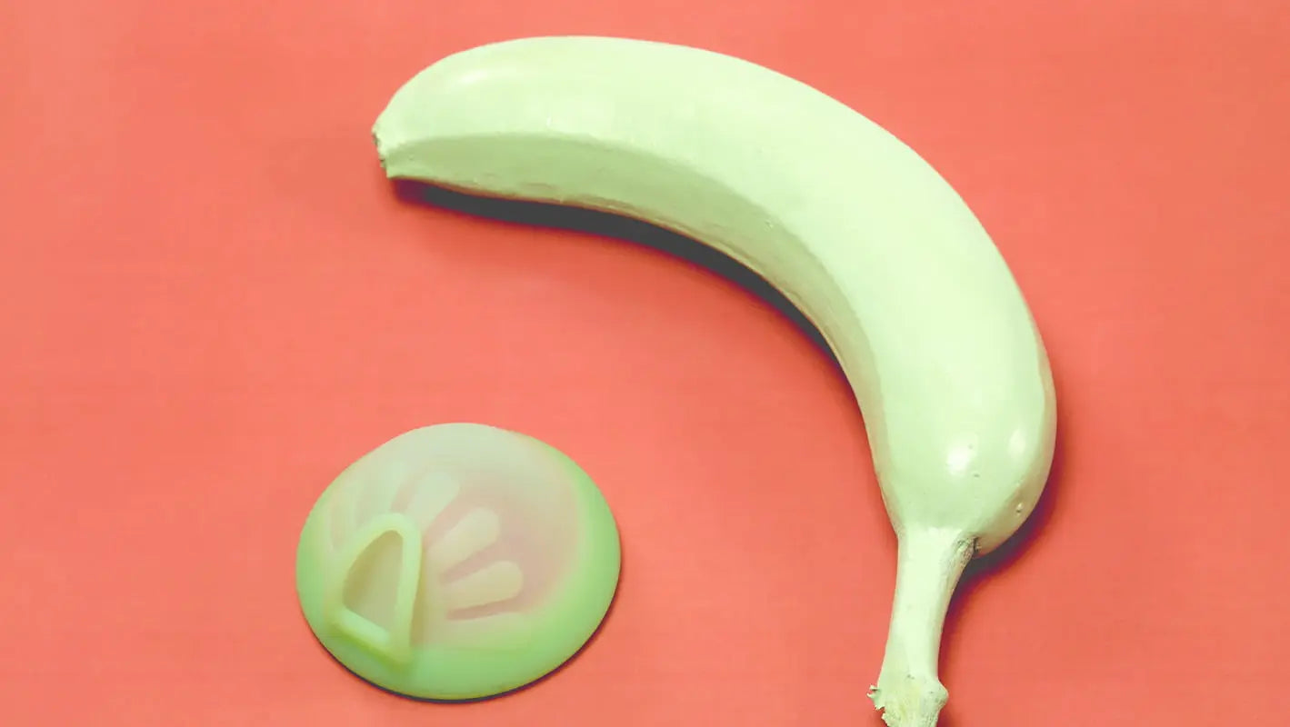 Discul menstrual Femi.Eko® alături de o banană, simbolizând în mod creativ și discret posibilitatea de a avea relații intime confortabile și sigure în timpul menstruației.